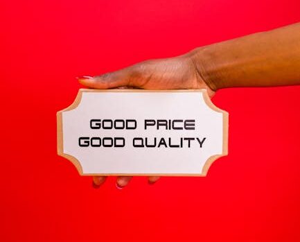 A hand holding a sign with 'Good Price, Good Quality' text against a bright red background.