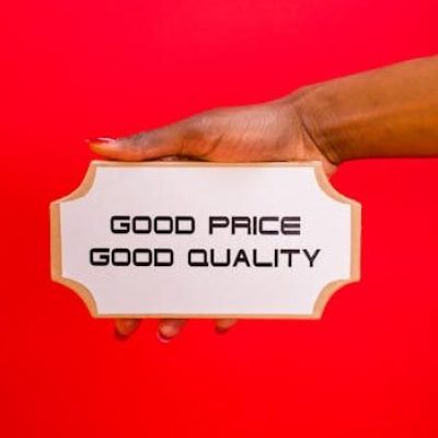 A hand holding a sign with 'Good Price, Good Quality' text against a bright red background.